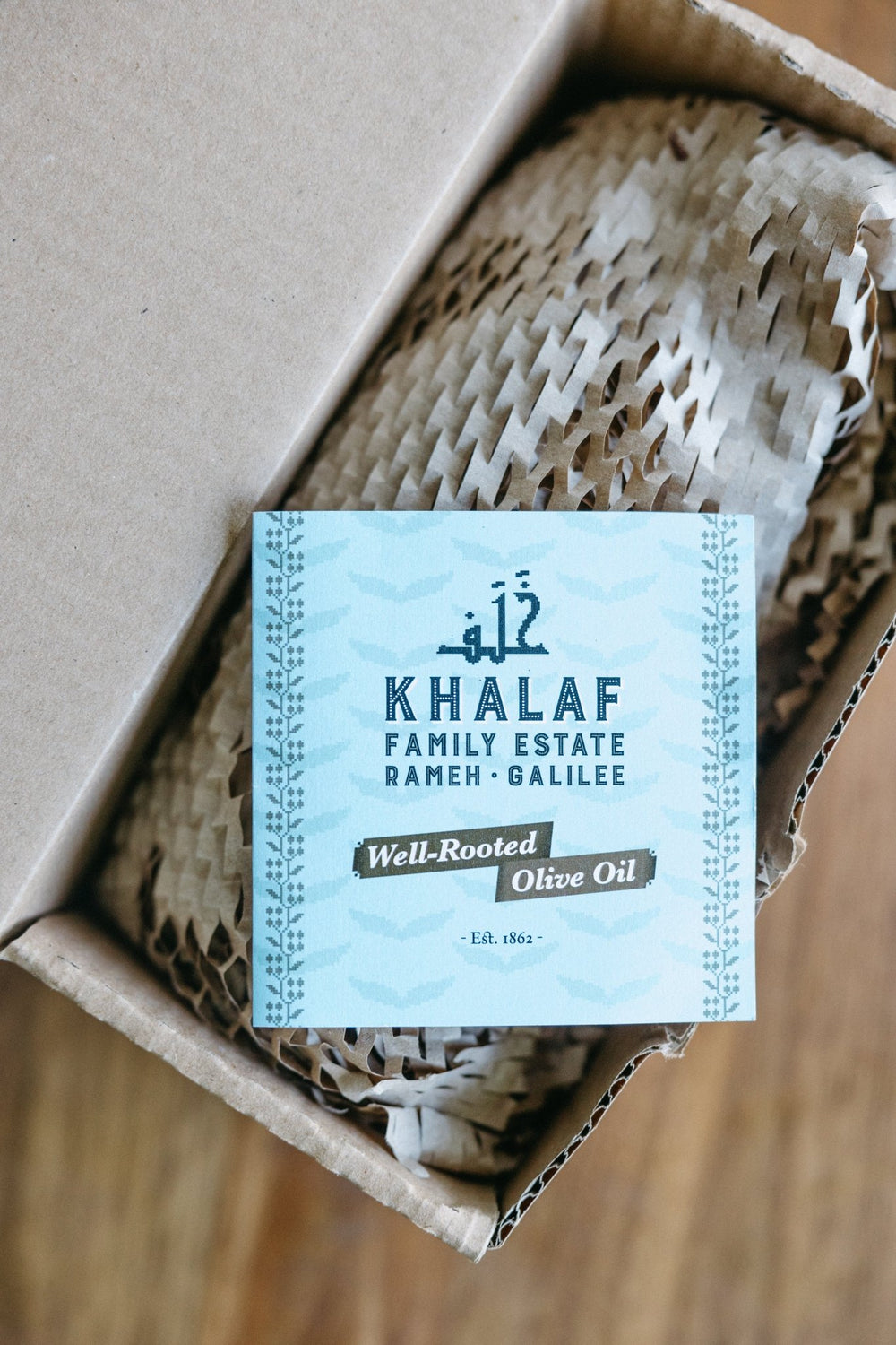 Elegant dark glass packaging of Khalaf Olives extra virgin olive oil, featuring minimalist design and traditional Souri olive heritage branding